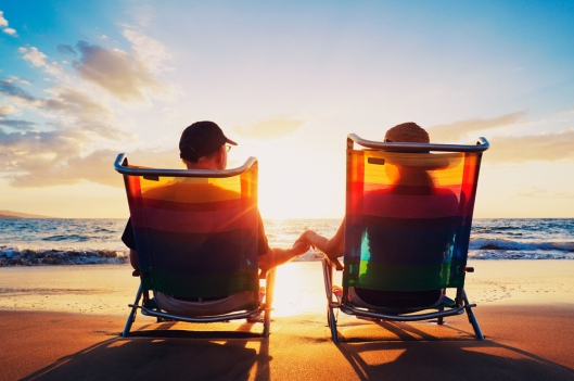 senior couple of old man and woman sitting on the beach watching